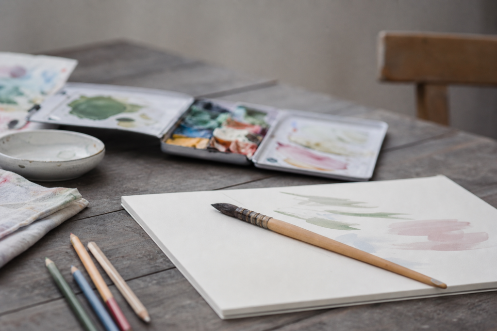 Vorbereiteter kunsttherapeutischer Arbeitsplatz mit Papier und Farben